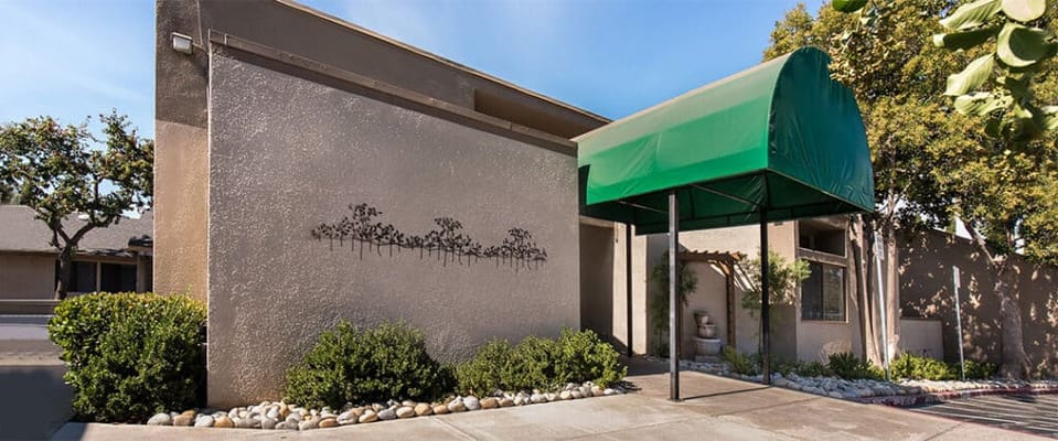 Exterior view of a senior living facility with a green awning