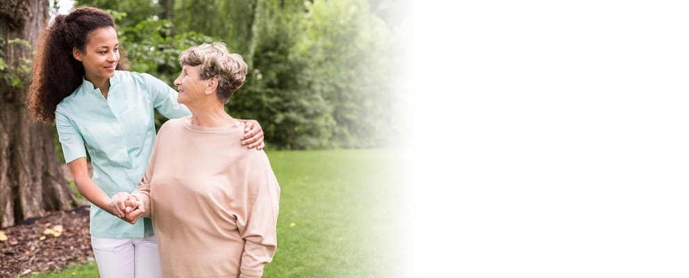 Caregiver assisting a senior woman outdoors