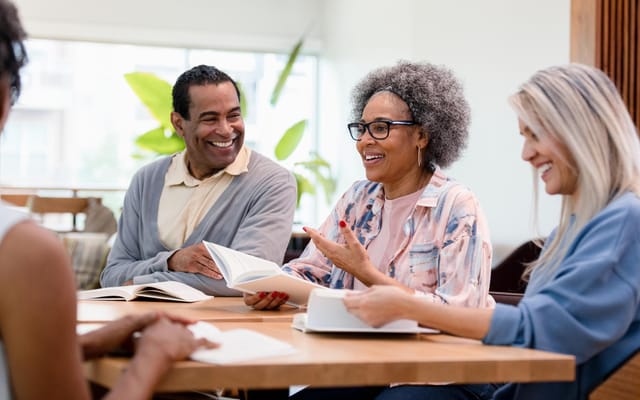 Residents engaged in a discussion at a communal table