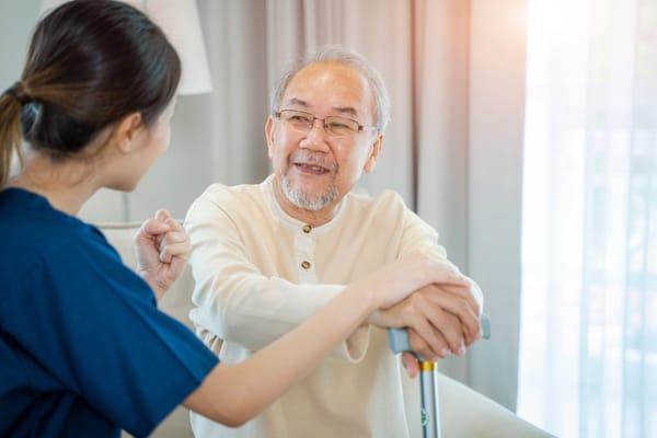 A caregiver interacting with an elderly resident indoors