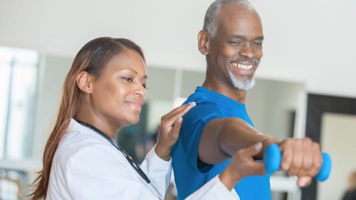 A caregiver assisting a senior with exercise using weights