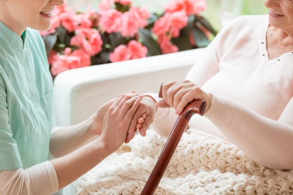 Caregiver assisting a resident in a cozy setting