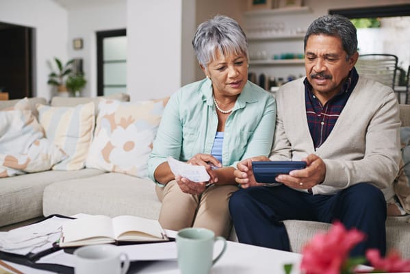 Two seniors engaging with a tablet in a cozy living room