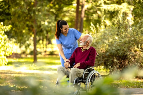 Caregiver assisting senior man in a garden