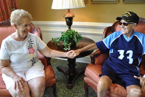 Two residents holding hands in a common area