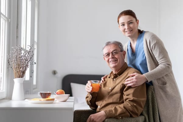 A caregiver and resident enjoying a drink together