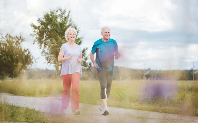 Active seniors jogging together on a path