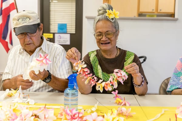 Residents crafting flower leis in an activity room