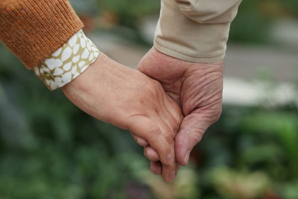 Two hands holding in a caring gesture