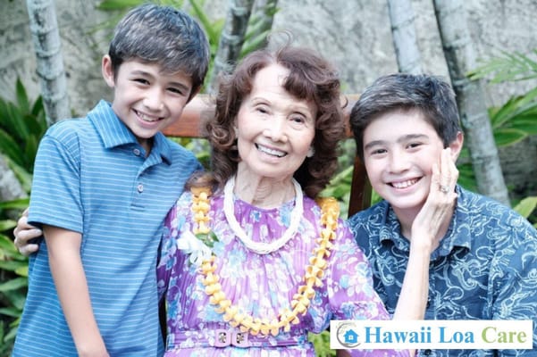 A woman with two children, smiling outdoors