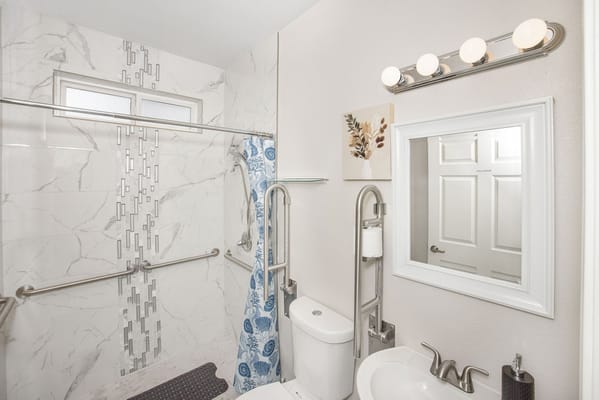 Well-lit bathroom with modern fixtures and grab bars
