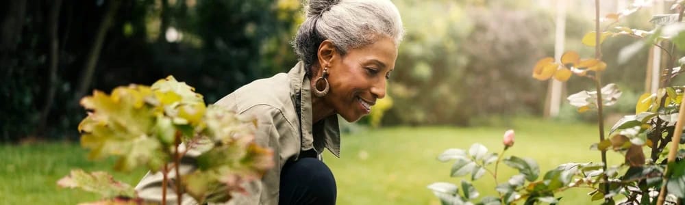 A resident enjoying gardening in a beautiful outdoor space
