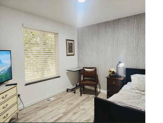 Cozy resident room with a bed, chair, and TV