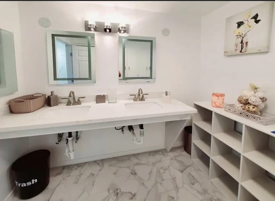 Bright bathroom with dual sinks and storage