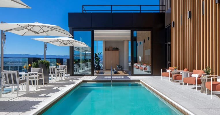 Outdoor pool area with seating and umbrellas