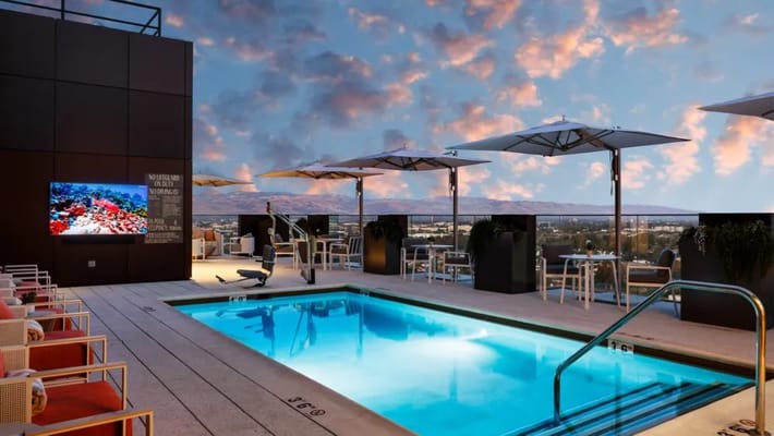 Rooftop pool area with seating and umbrellas