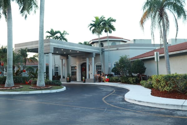 Front entrance of HarborChase of Tamarac with palm trees