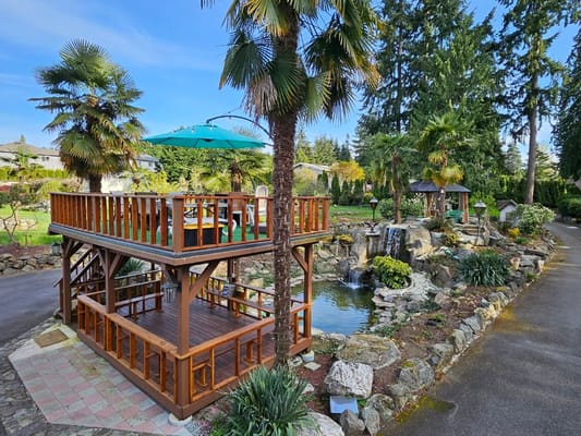 Outdoor garden area with wooden deck and pond