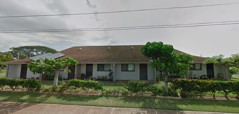 Front view of DE Thompson Village showing residential buildings and landscaping.