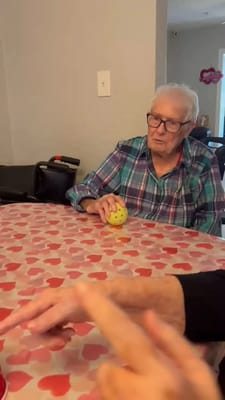 Resident interacting with a ball at a table