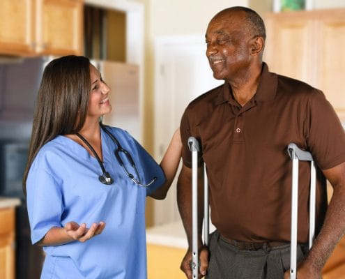 Nurse assisting resident in a bright kitchen area