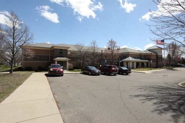 Exterior view of Village of Harmony Manor showing entrance and parking area.