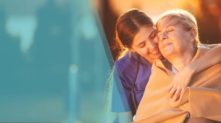 A caregiver embracing a resident outdoors