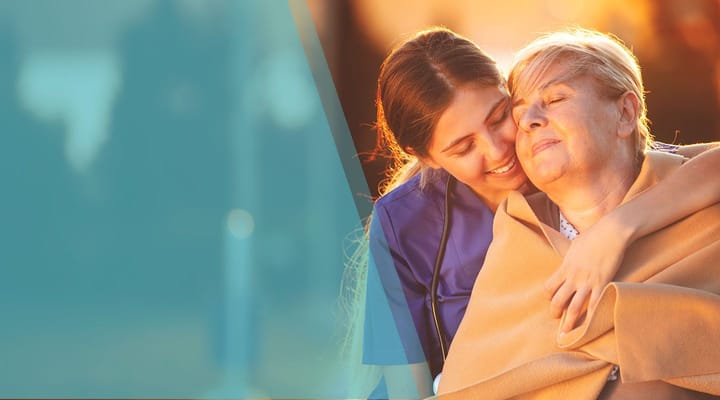 A caregiver embracing a resident outdoors
