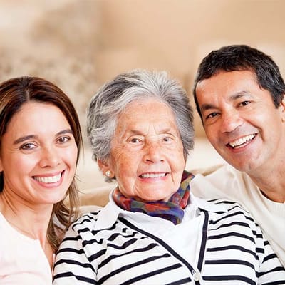 A smiling elderly woman with two adults