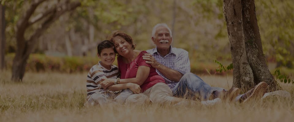 Family enjoying a sunny day outdoors at a senior living facility