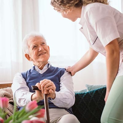 Caregiver interacting with an elderly resident in a cozy setting