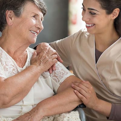 A caregiver smiling with a resident in a care facility