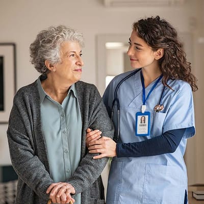 A caregiver assisting a senior resident in a welcoming interior