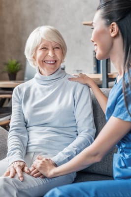 A caregiver smiling while talking to a resident