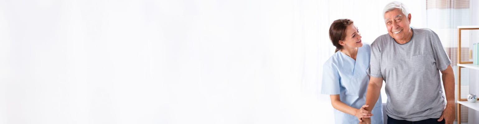 A caregiver smiling with a resident in a bright interior