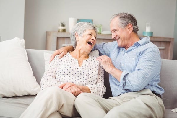 Senior couple sharing a joyful moment on a sofa