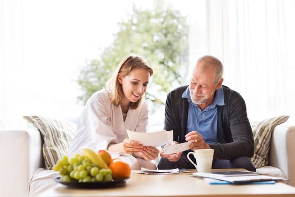 A caregiver and resident sharing documents in a cozy setting