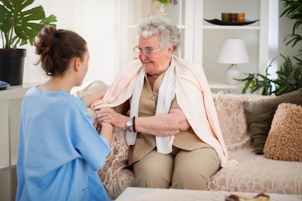 Caregiver interacting with a resident in a cozy indoor setting.