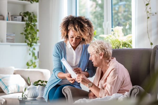 Caregiver assisting a resident in a cozy living room