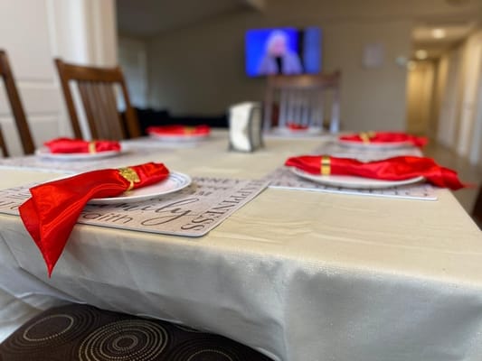 Dining table set for a meal with red napkins