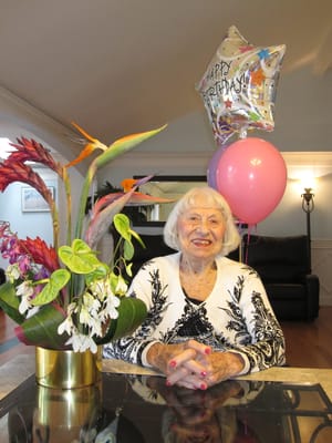 An elderly woman celebrating her birthday with decorations