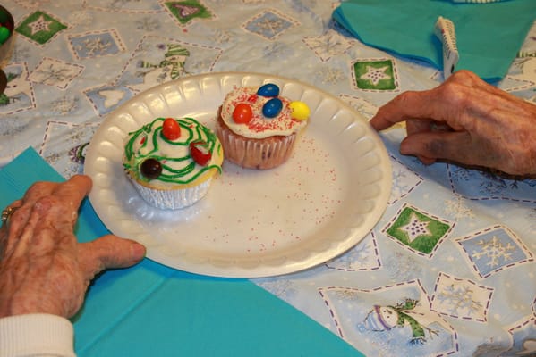 Hands enjoying decorated cupcakes at a festive table