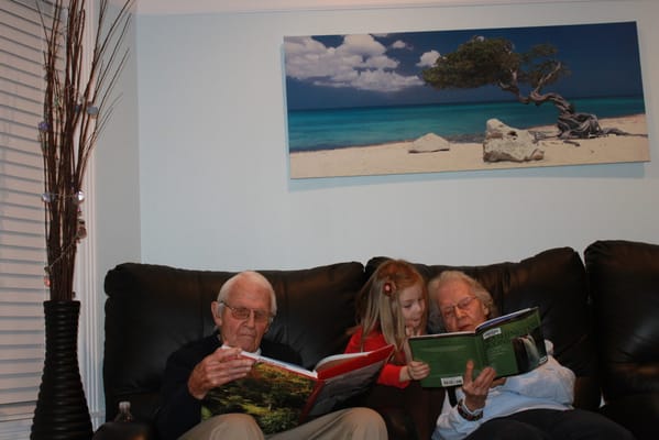 Seniors reading with a young child in a cozy living room