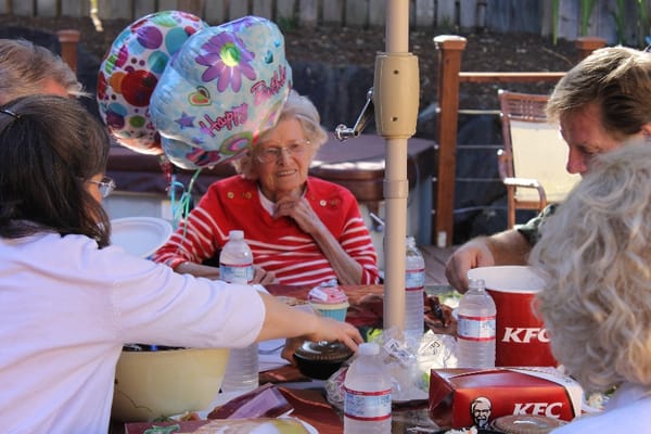 Residents celebrating a birthday with food and balloons