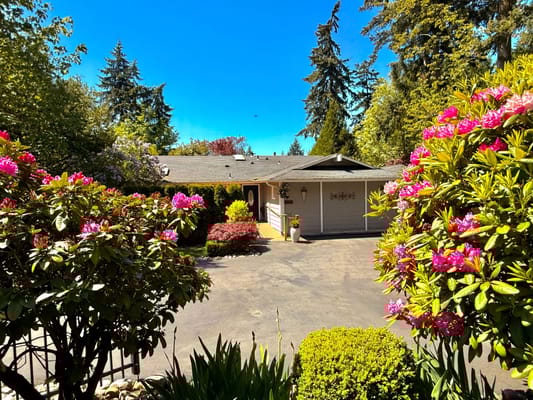 Exterior view of a senior living facility surrounded by flowers