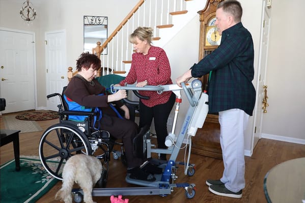 Caregivers assisting a resident using a lift