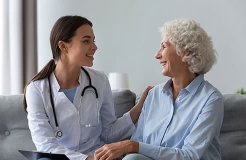 A caregiver and resident smiling in a cozy setting