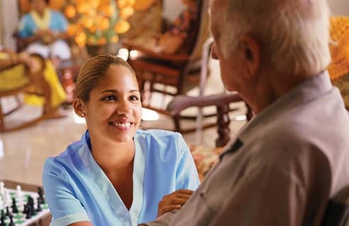 Staff member engaging with an elder resident in a common area