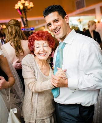 A resident dancing joyfully with a staff member at a celebration