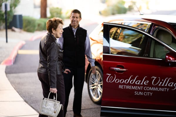 A resident and staff member outside a vehicle at Wooddale Village.